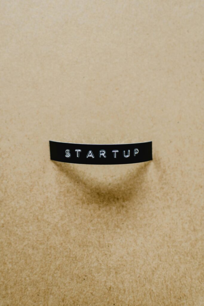 A minimalist image of the word 'STARTUP' on a beige textured surface conveying creative business concepts.